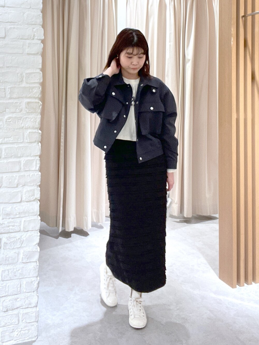 ベージュ系のTシャツ/カットソー、ブラック系のスカート、ブラック系のショルダーバッグを着用したレディースの春コーディネートの2枚目の写真