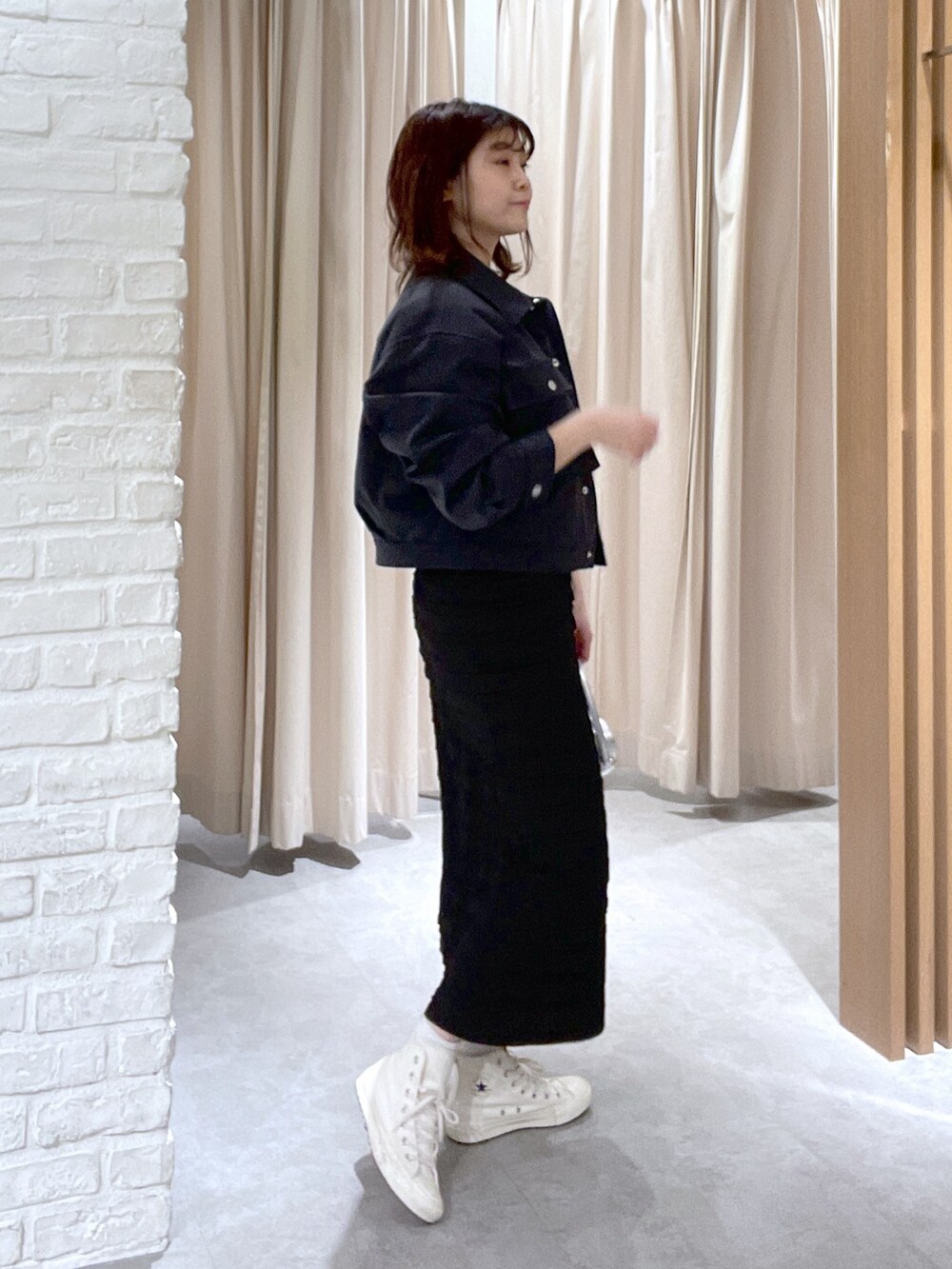 ベージュ系のTシャツ/カットソー、ブラック系のスカート、ブラック系のショルダーバッグを着用したレディースの春コーディネートの3枚目の写真