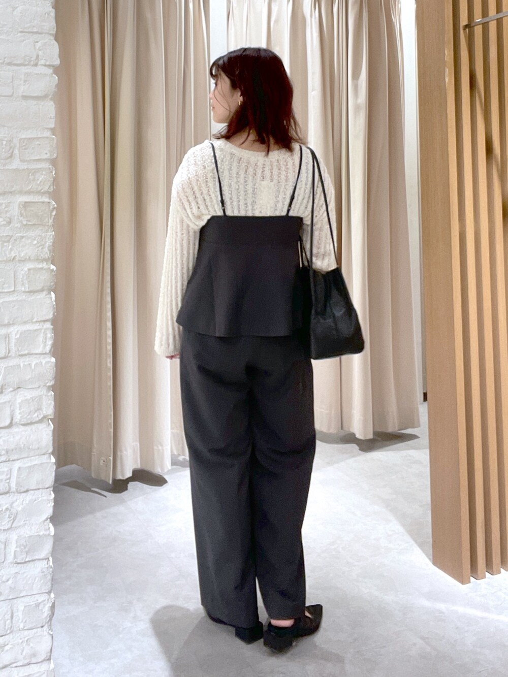 ホワイト系のニット/セーター、ブラック系のシャツ/ブラウス、ブラック系のスラックスを着用したレディースの春コーディネートの3枚目の写真