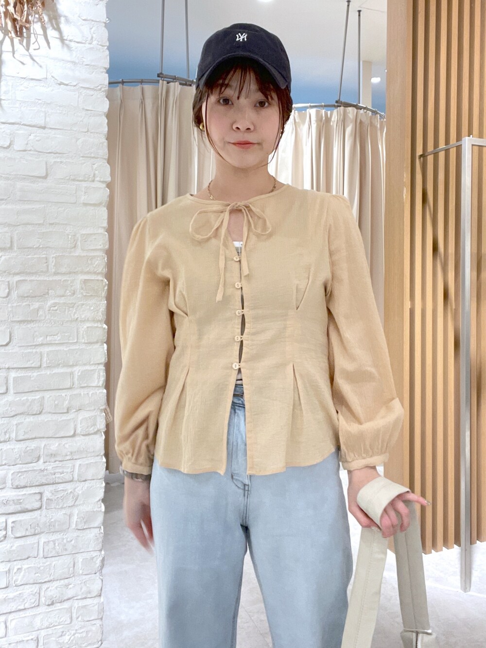 イエロー系のシャツ/ブラウス、ホワイト系のショルダーバッグ、ブルー系のデニムパンツを着用したレディースの春コーディネートの4枚目の写真