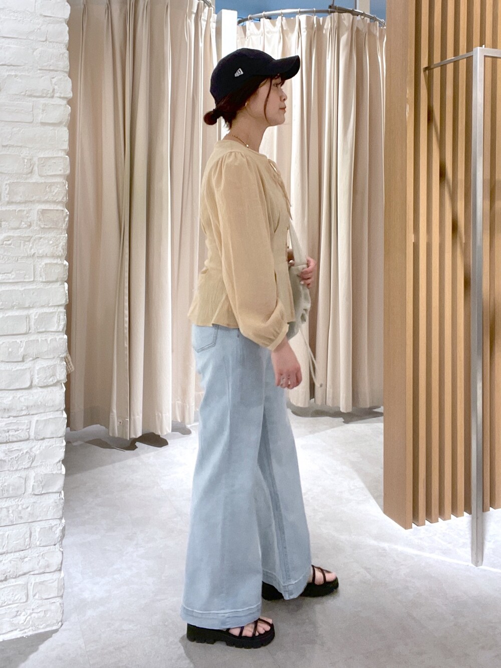 イエロー系のシャツ/ブラウス、ホワイト系のショルダーバッグ、ブルー系のデニムパンツを着用したレディースの春コーディネートの3枚目の写真