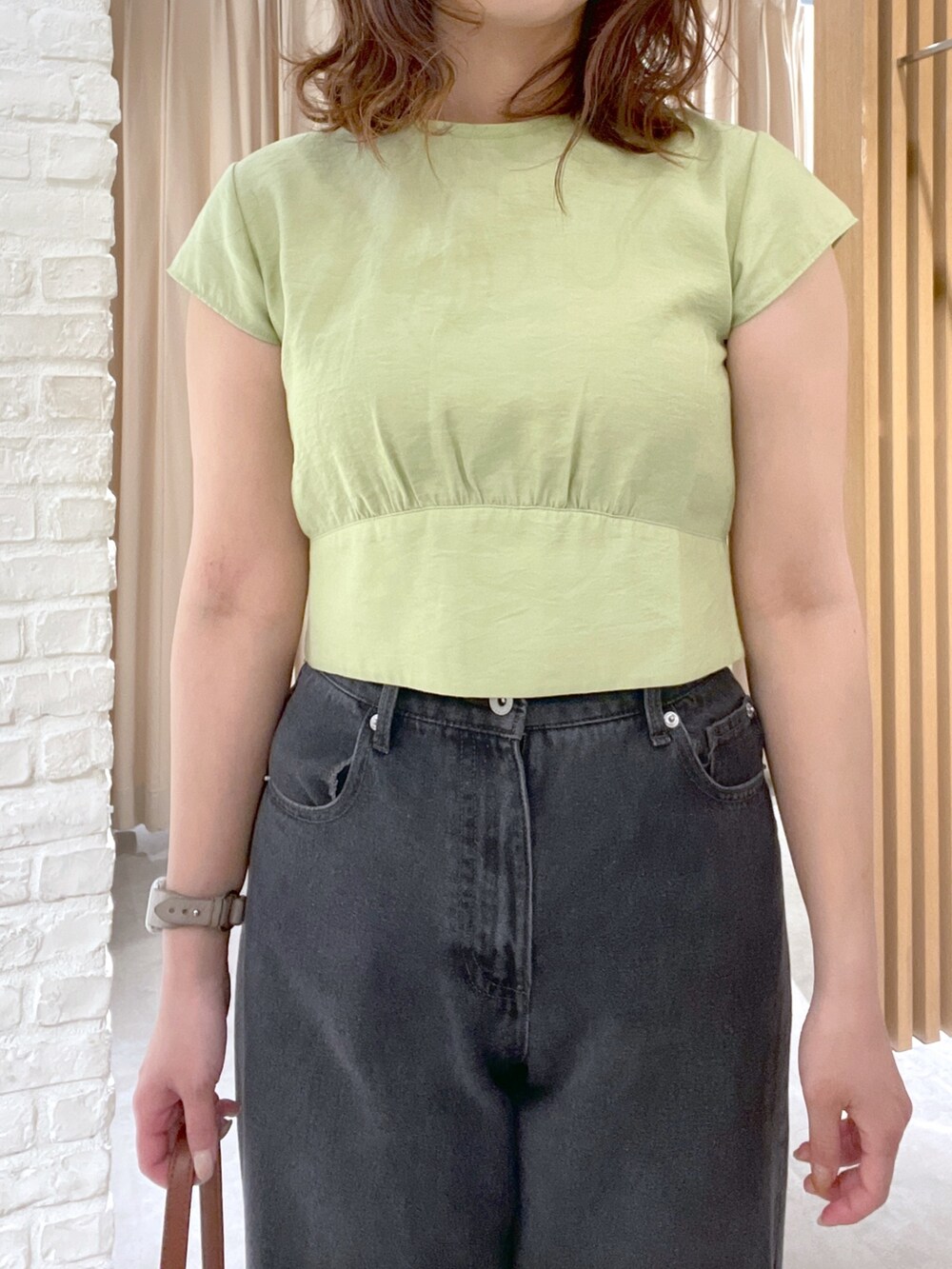 グリーン系のシャツ/ブラウス、ブラック系のデニムパンツ、ベージュ系のショルダーバッグを着用したレディースの春コーディネートの4枚目の写真