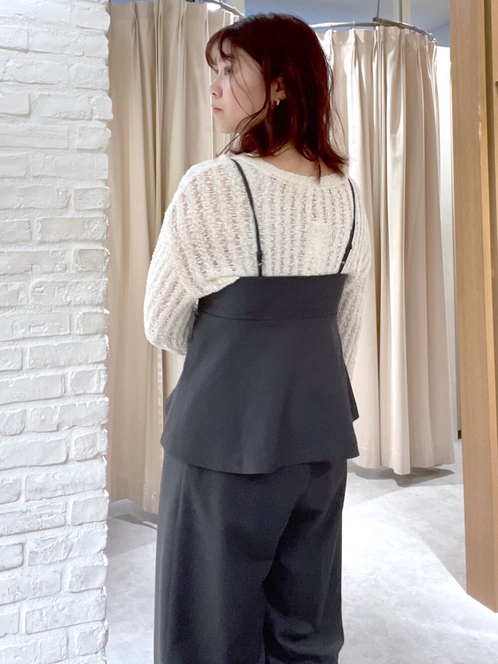 ホワイト系のニット/セーター、ブラック系のシャツ/ブラウス、ブラック系のスラックスを着用したレディースの春コーディネートの5枚目の写真