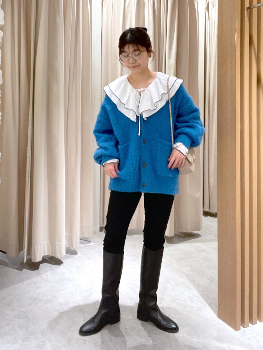 ホワイト系のシャツ/ブラウス、ブルー系のカーディガン/ボレロ、ブラック系のデニムパンツを着用したレディースの冬コーディネートの2枚目の写真