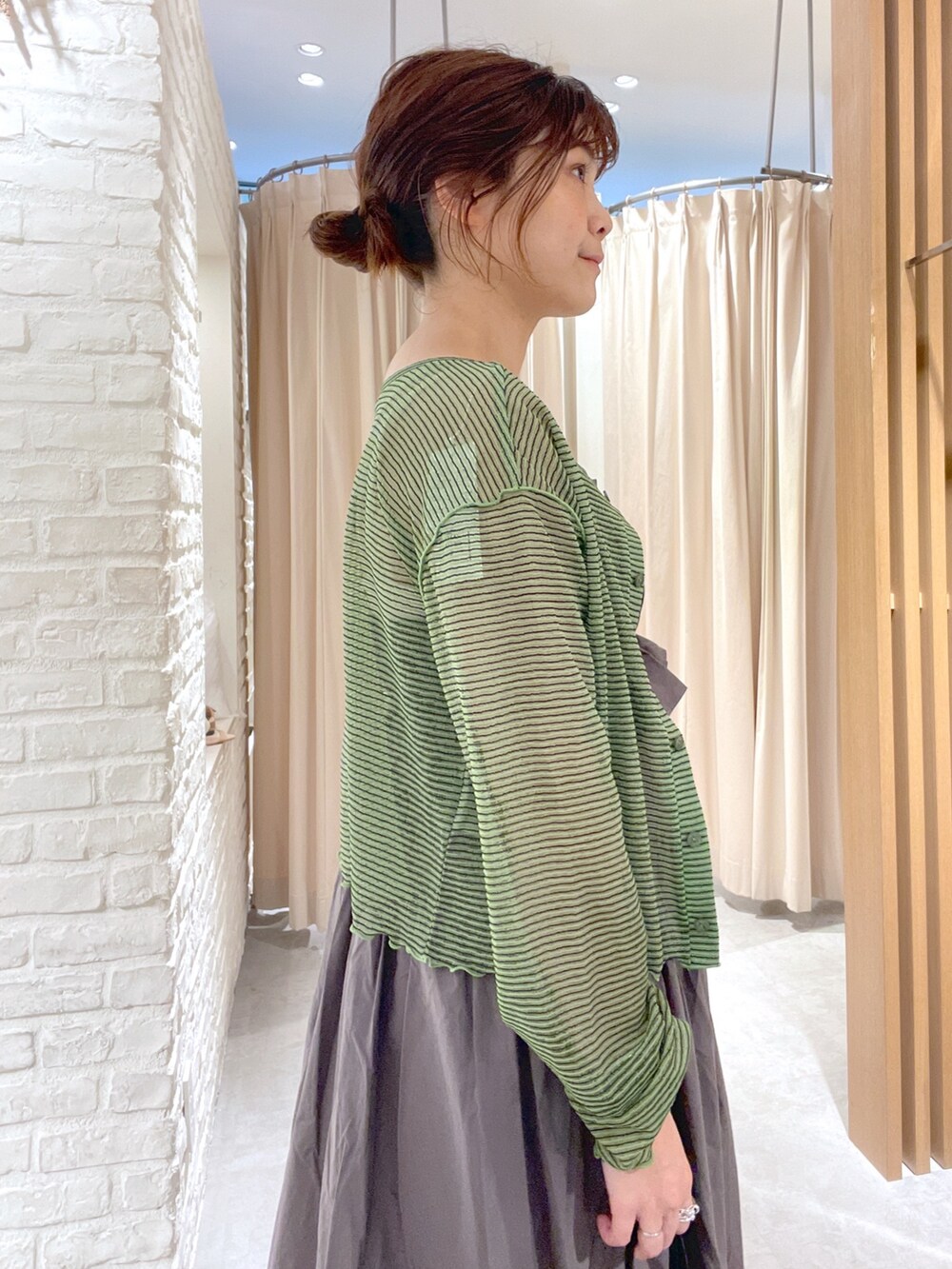 グリーン系のカーディガン/ボレロ、グレー系のワンピース、ブラック系のサンダルを着用したレディースの夏コーディネートの4枚目の写真