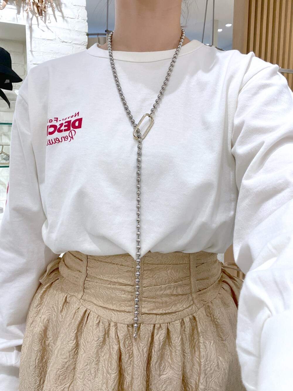 ホワイト系のTシャツ/カットソー、ブラック系のハンドバッグ、ブラック系のパンプスを着用したレディースの春コーディネートの5枚目の写真