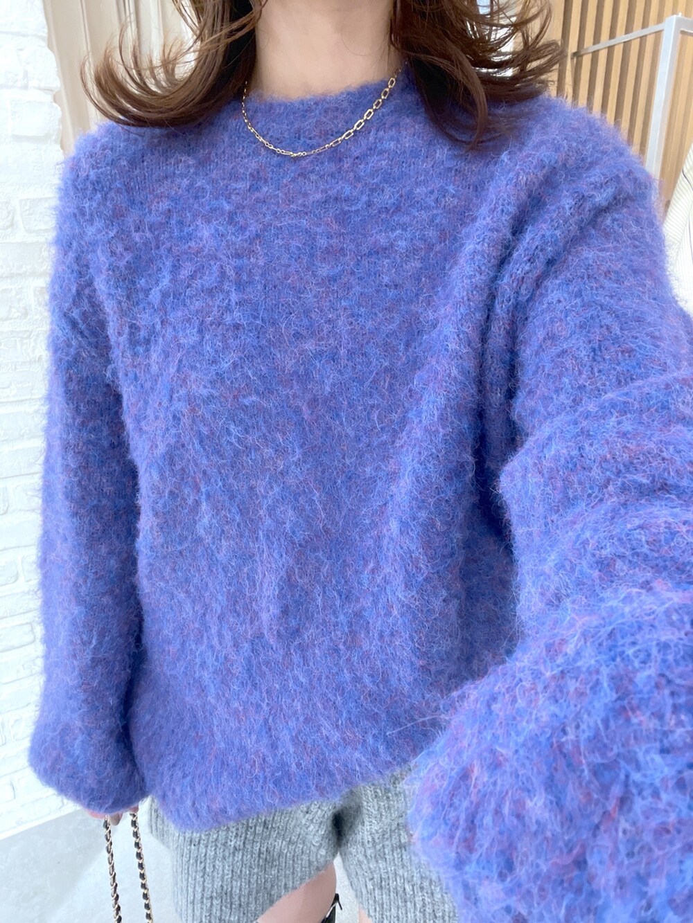 ブルー系のニット/セーター、グレー系のその他パンツ、ブラック系のブーツを着用したレディースの冬コーディネートの4枚目の写真