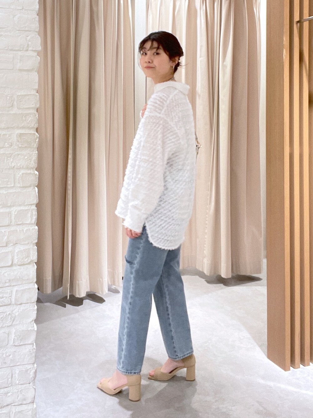 ホワイト系のシャツ/ブラウス、ブルー系のデニムパンツ、ホワイト系のショルダーバッグを着用したレディースの春コーディネートの3枚目の写真