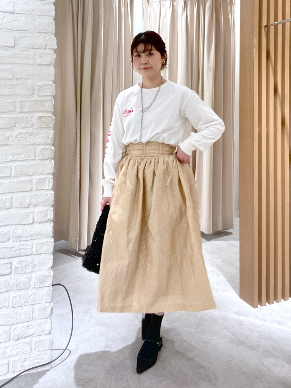 ホワイト系のTシャツ/カットソー、ブラック系のハンドバッグ、ブラック系のパンプスを着用したレディースの春コーディネートの2枚目の写真