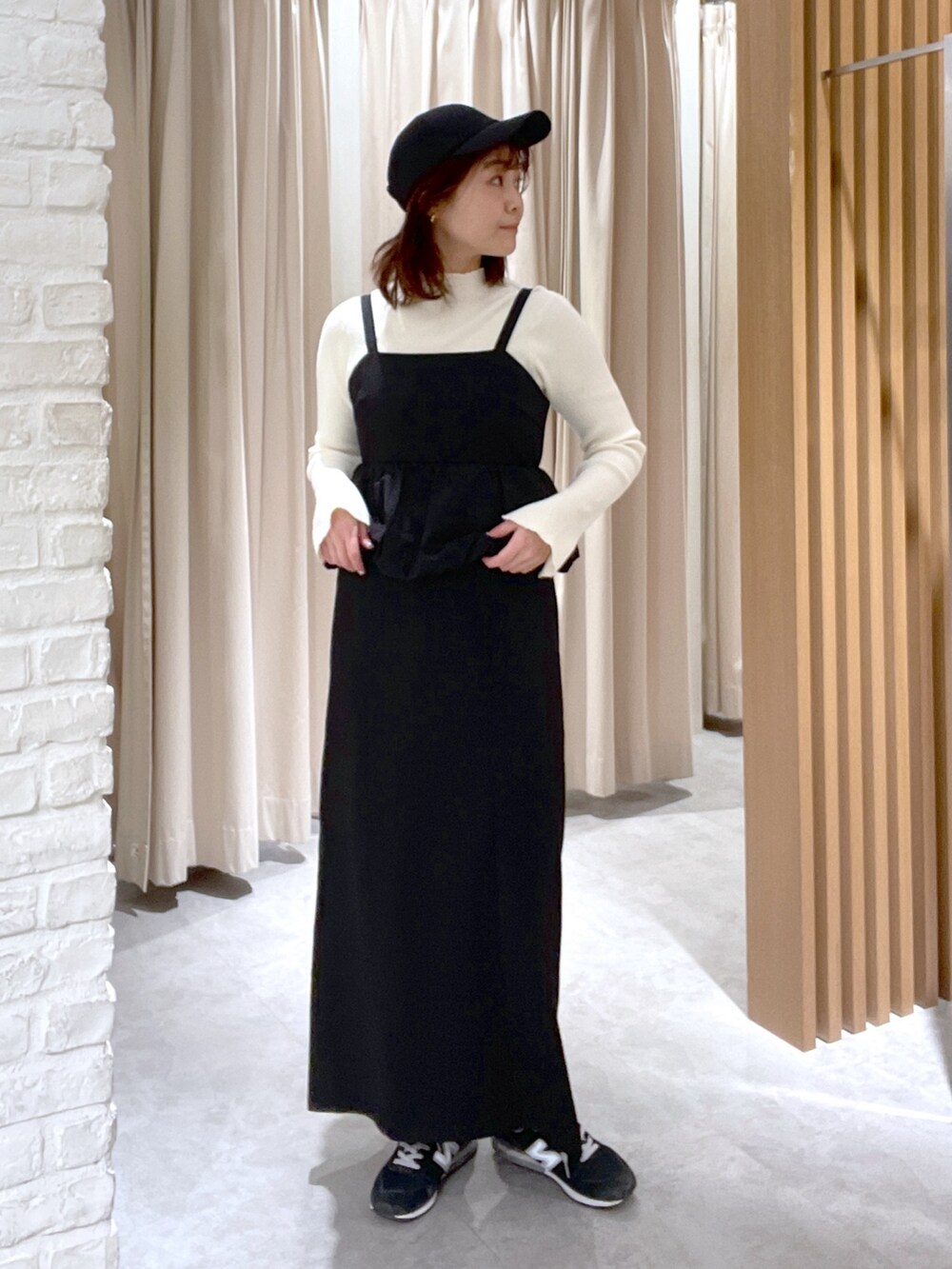 ホワイト系のニット/セーター、ブラック系のワンピース、ブラック系のショルダーバッグを着用したレディースの冬コーディネートの2枚目の写真