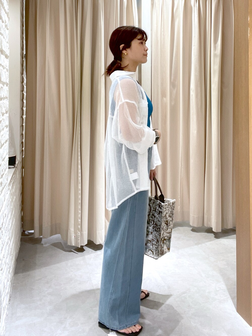 ブルー系のタンクトップ、ブルー系のデニムパンツ、ホワイト系のシャツ/ブラウスを着用したレディースの夏コーディネートの2枚目の写真