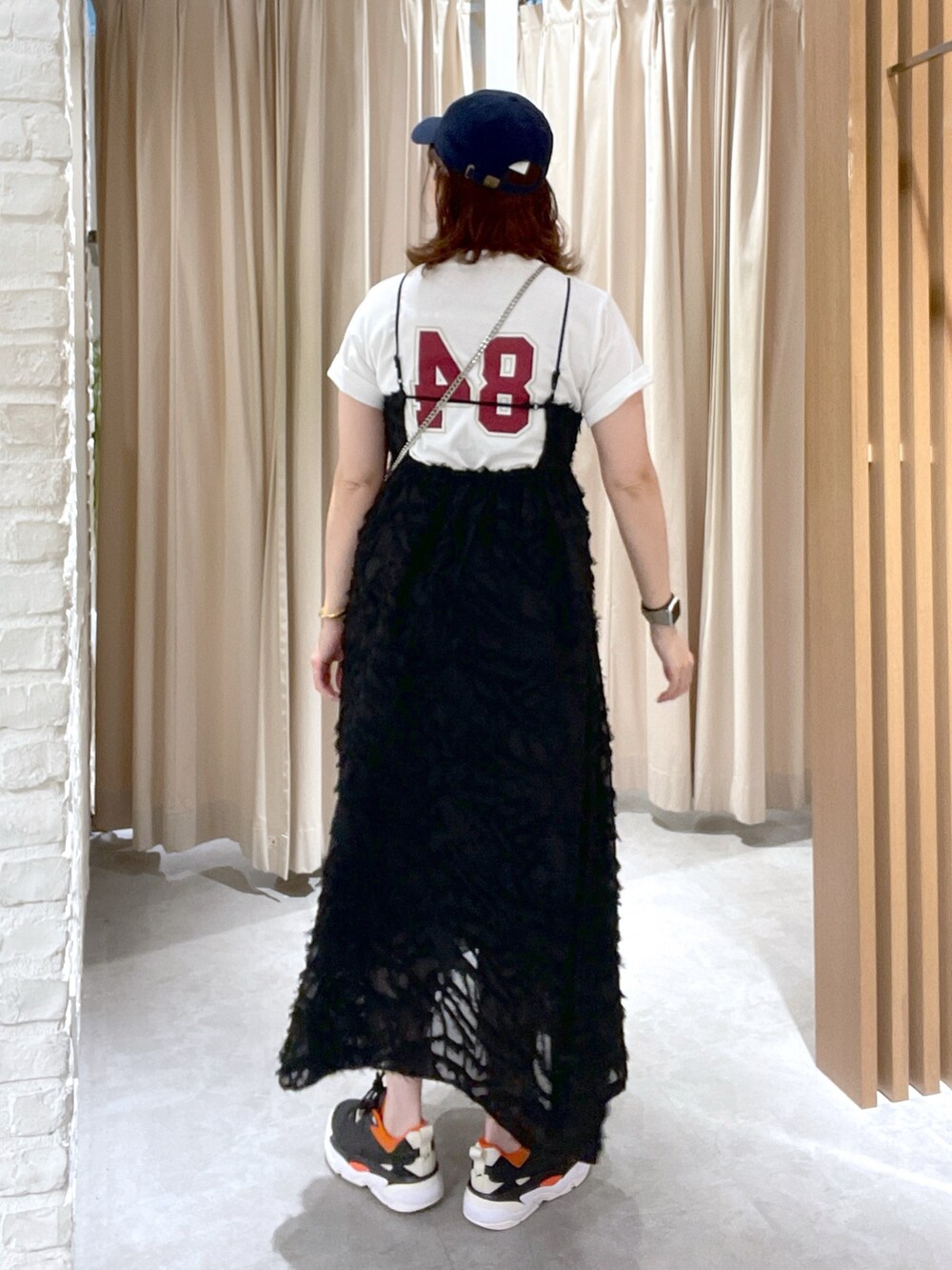 ホワイト系のTシャツ/カットソー、ブラック系のワンピース、ブルー系のキャップを着用したレディースの夏コーディネートの2枚目の写真