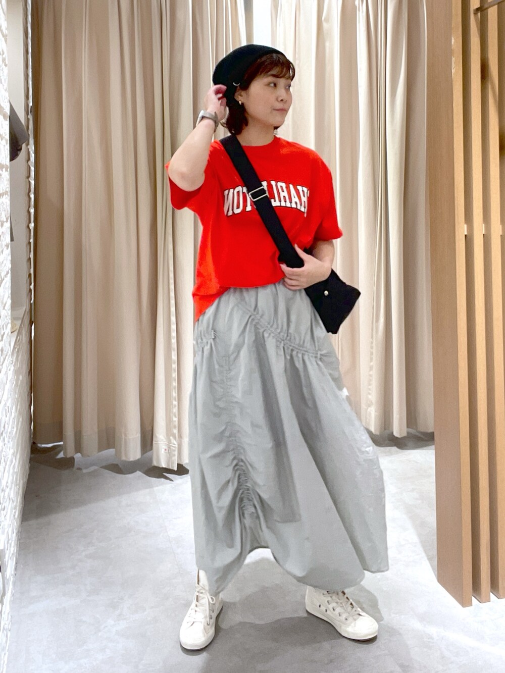 レッド系のTシャツ/カットソー、ブラック系のショルダーバッグ、グレー系のスカートを着用したレディースの夏コーディネートの2枚目の写真