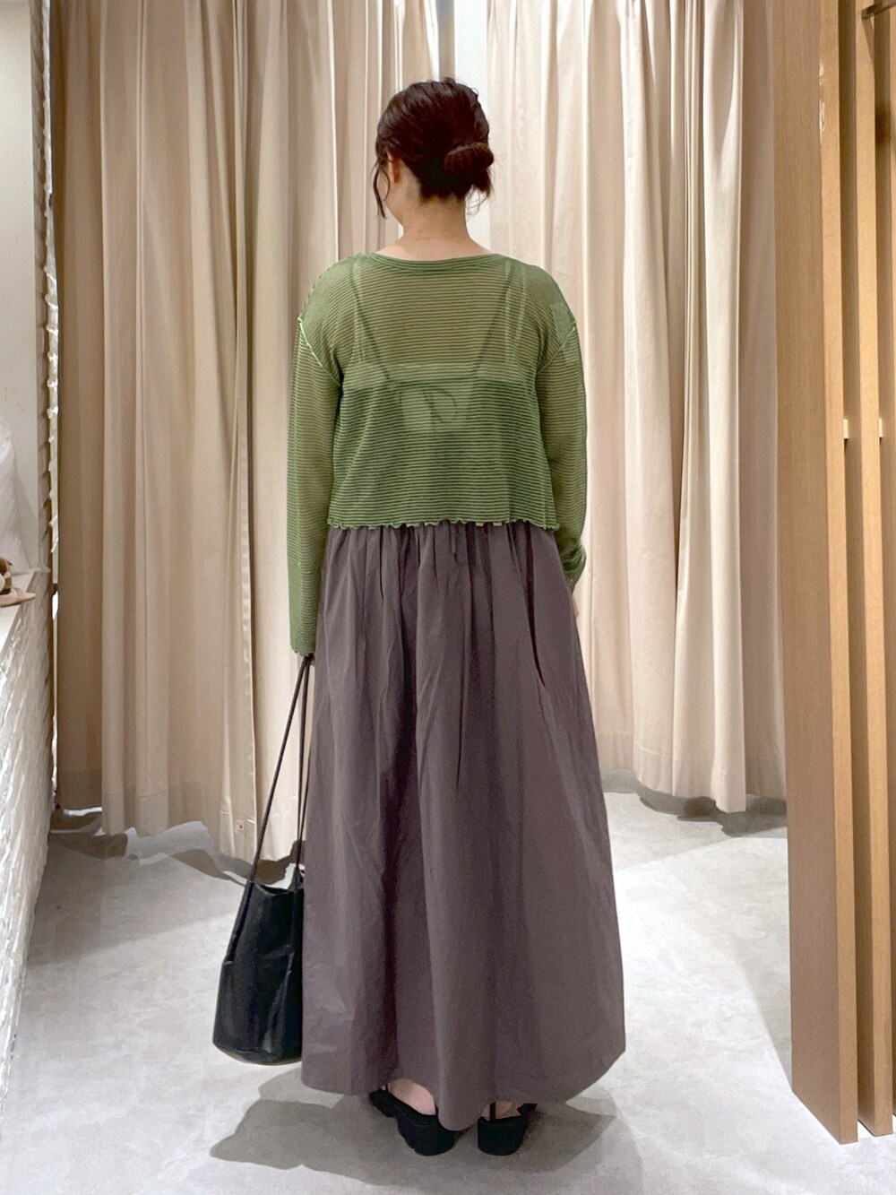 グリーン系のカーディガン/ボレロ、グレー系のワンピース、ブラック系のサンダルを着用したレディースの夏コーディネートの3枚目の写真