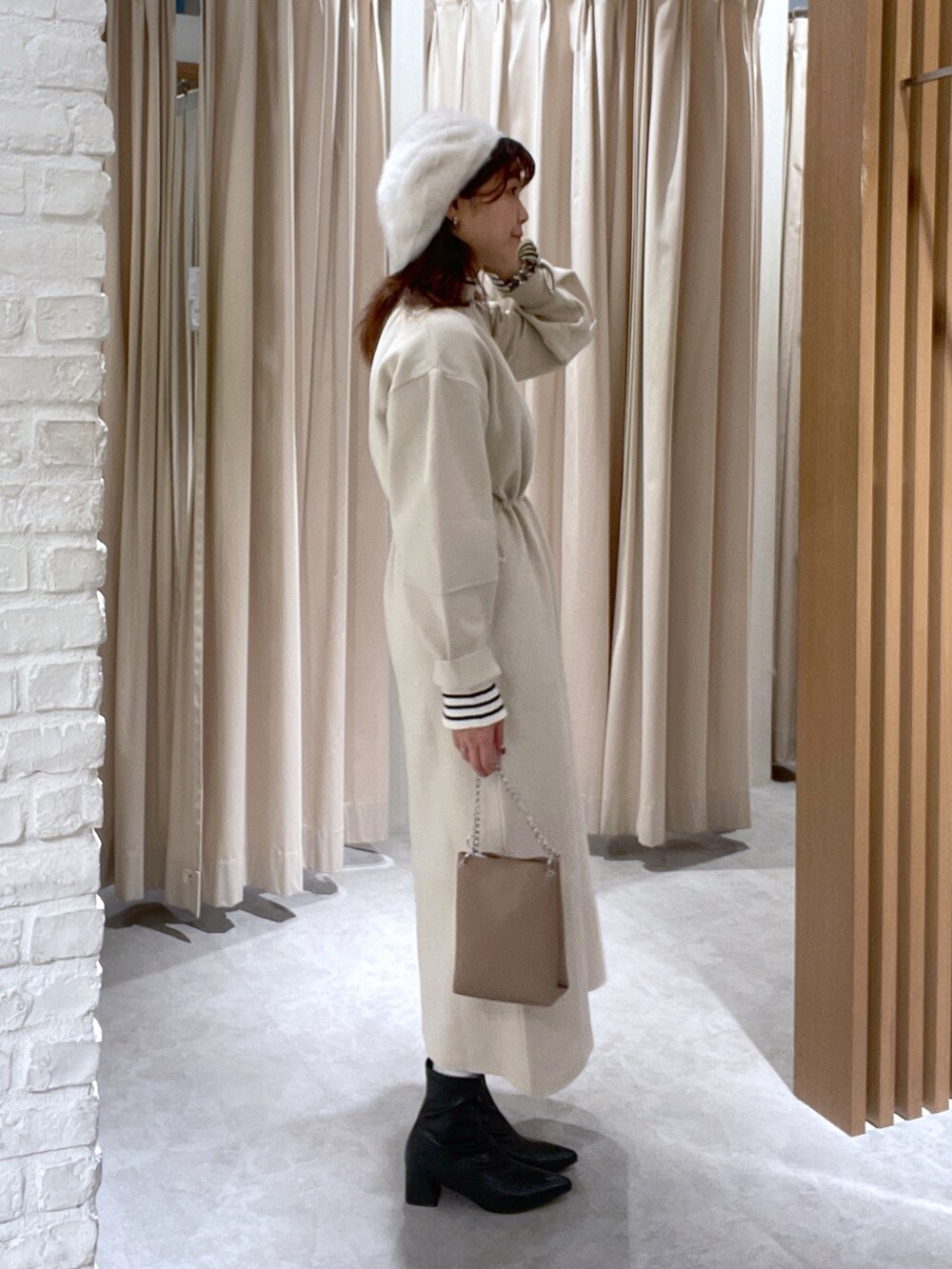 ホワイト系のワンピース、ホワイト系のニット/セーター、ベージュ系のショルダーバッグを着用したレディースの秋コーディネートの3枚目の写真