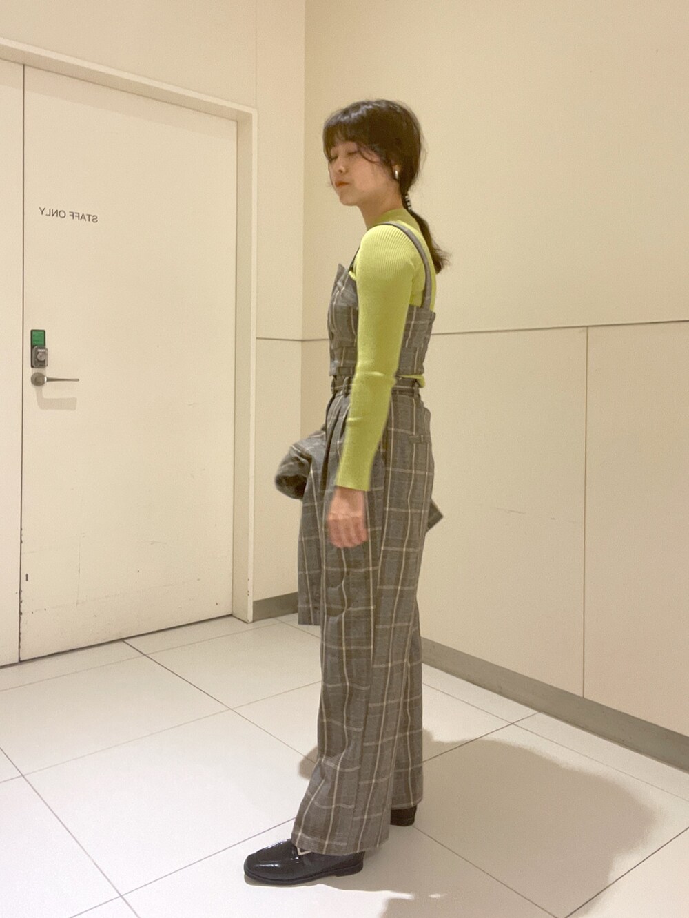 グリーン系のニット/セーター、グレー系のベスト、グレー系のテーラードジャケットを着用したレディースの秋コーディネートの5枚目の写真