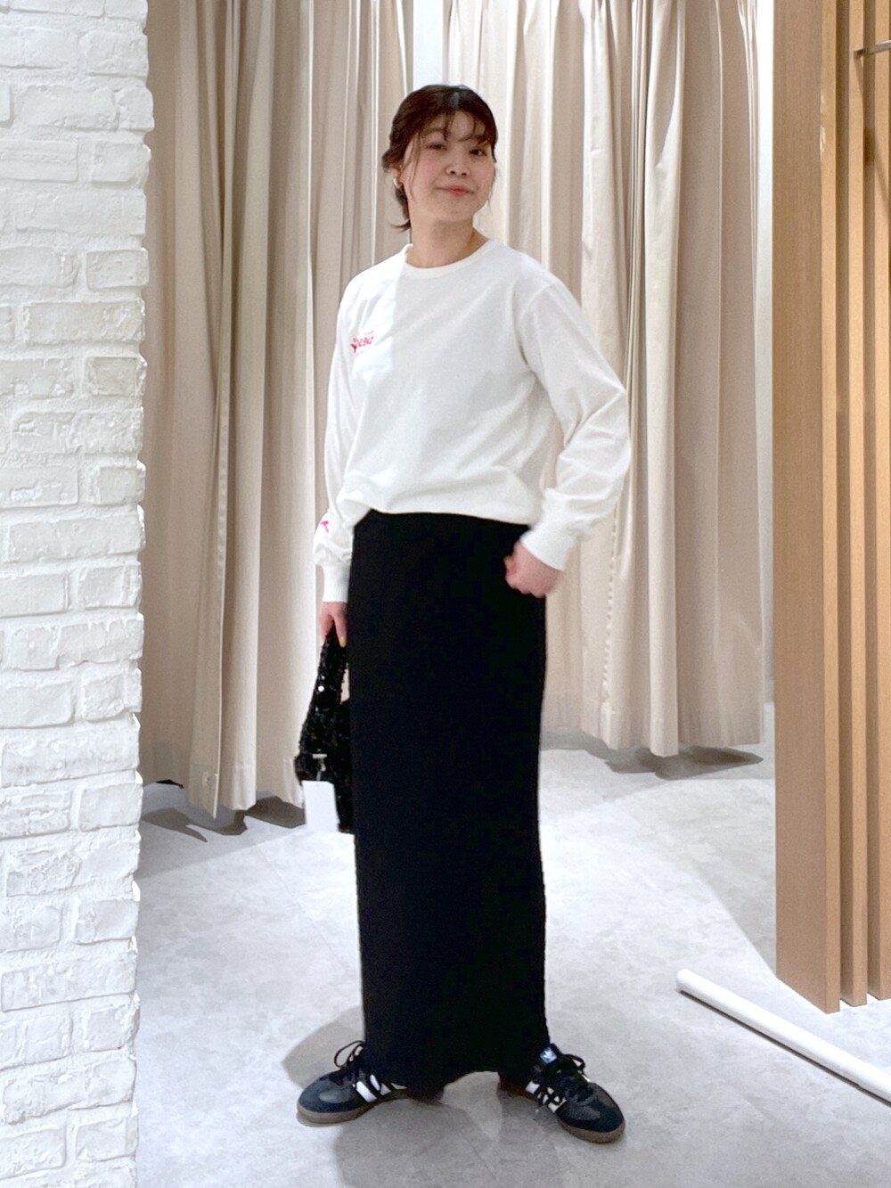 ベージュ系のマウンテンパーカー、ブラック系のスカート、ブラック系のハンドバッグを着用したレディースの春コーディネートの5枚目の写真