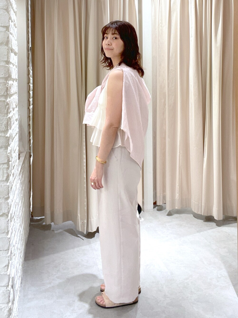 ピンク系のシャツ/ブラウス、ホワイト系のシャツ/ブラウス、ホワイト系のスラックスを着用したレディースの夏コーディネートの3枚目の写真