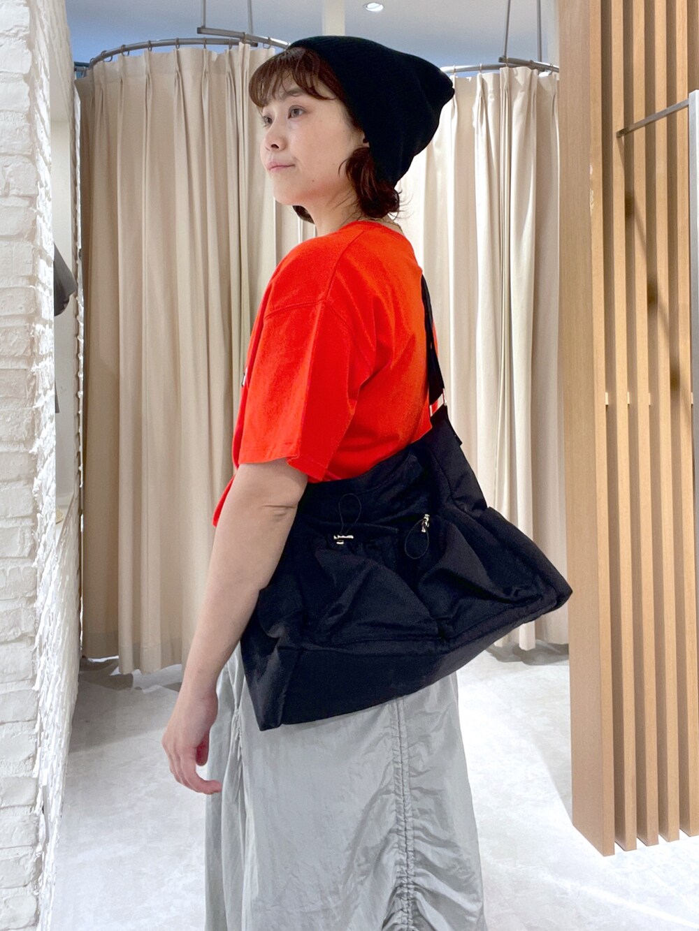 レッド系のTシャツ/カットソー、ブラック系のショルダーバッグ、グレー系のスカートを着用したレディースの夏コーディネートの5枚目の写真