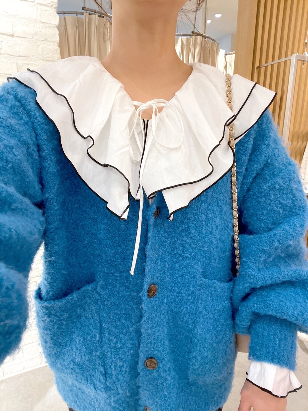 ホワイト系のシャツ/ブラウス、ブルー系のカーディガン/ボレロ、ブラック系のデニムパンツを着用したレディースの冬コーディネートの5枚目の写真