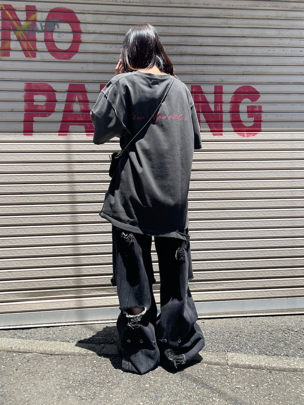グレー系のTシャツ/カットソー、ブラック系のデニムパンツ、ブラック系のスニーカーを着用したレディースの夏コーディネートの2枚目の写真