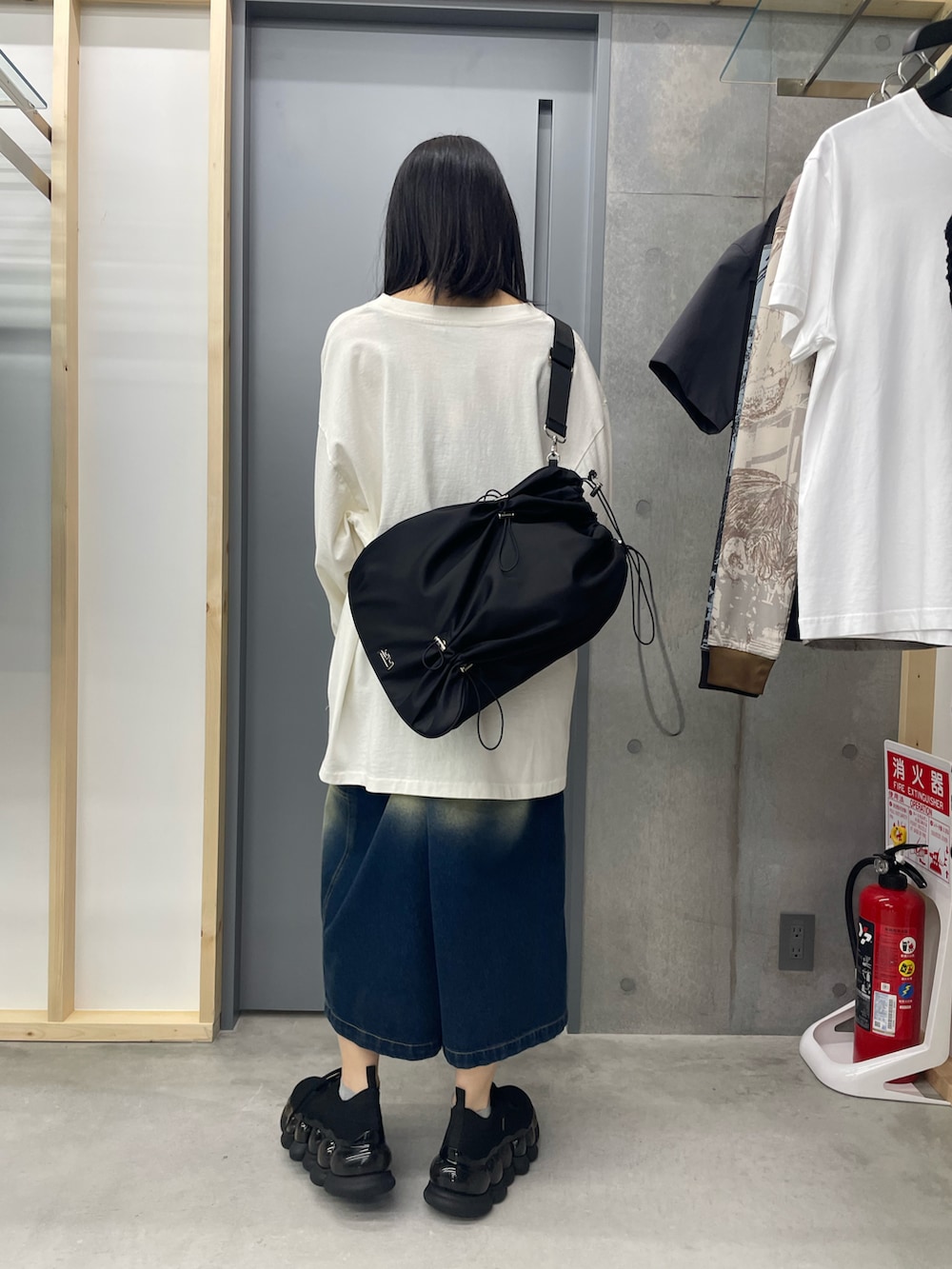 ホワイト系のTシャツ/カットソー、ブルー系のデニムパンツ、ブラック系のスニーカーを着用したレディースの夏コーディネートの2枚目の写真