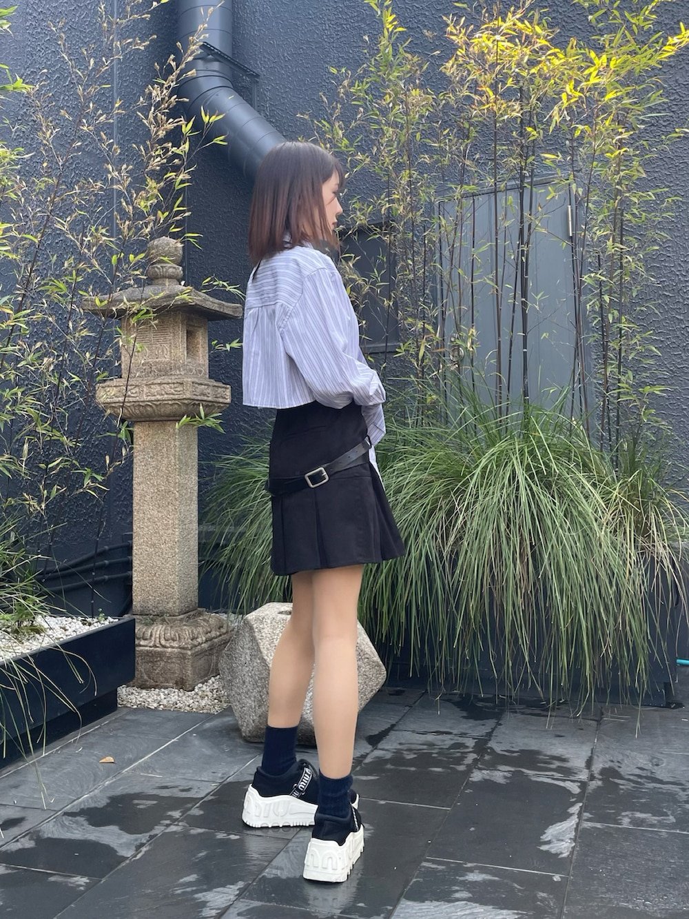 ブルー系のシャツ/ブラウス、ブラック系のスカートを着用したレディースの春コーディネートの2枚目の写真