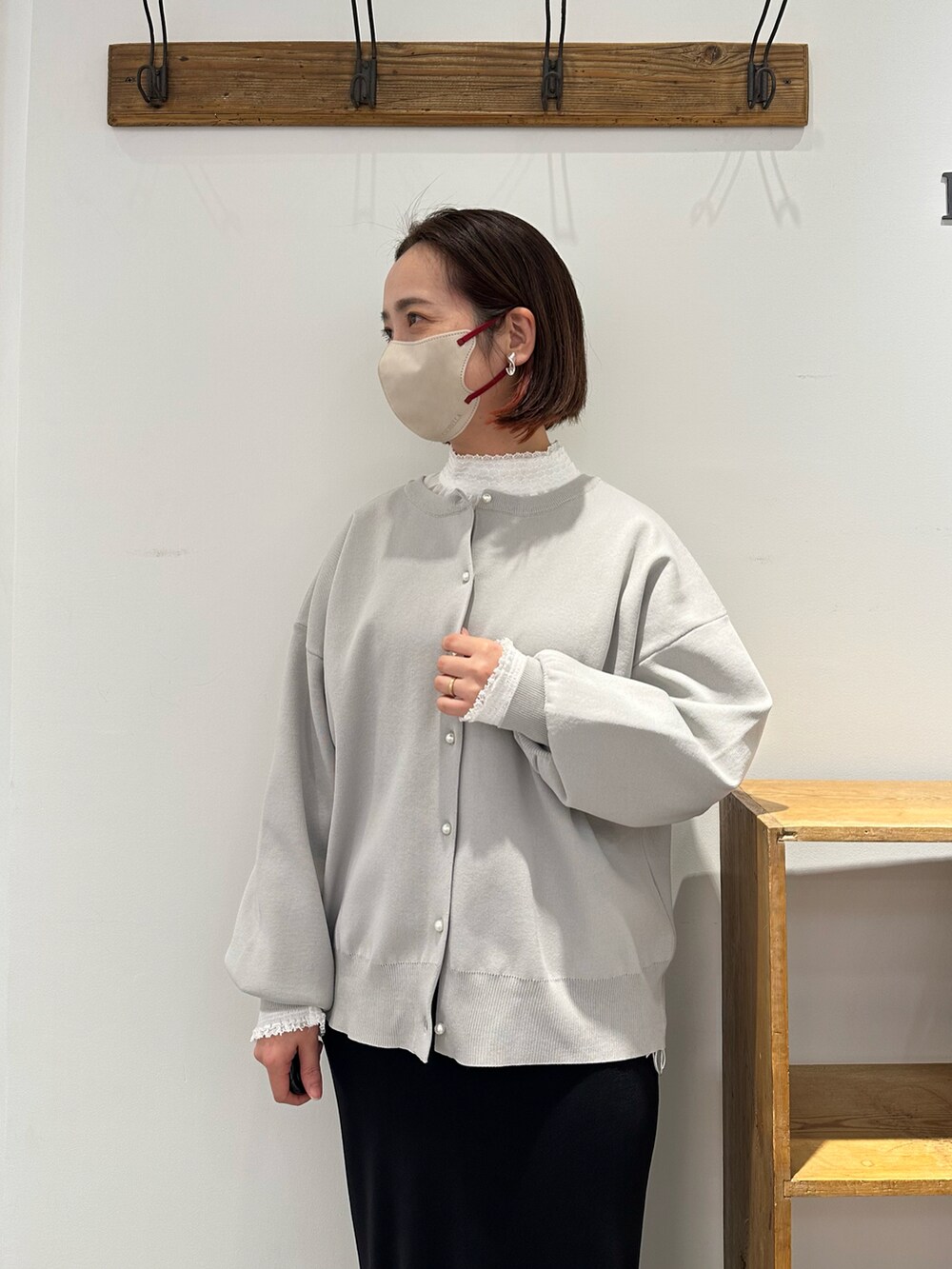 グレー系のカーディガン/ボレロ、ホワイト系のシャツ/ブラウス、ブラック系のスカートを着用したレディースの冬コーディネートの2枚目の写真