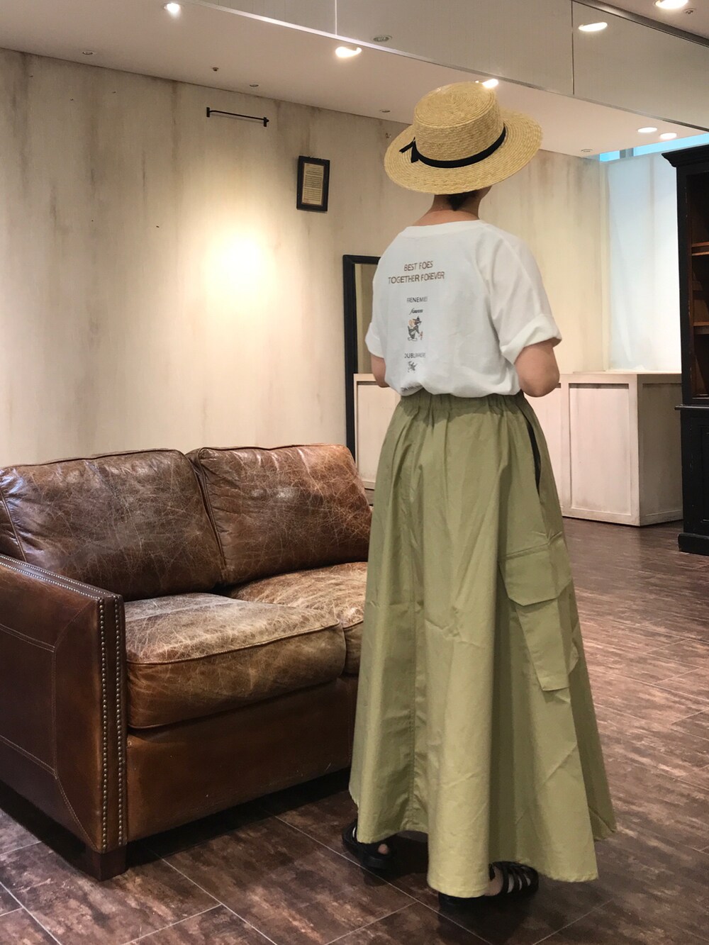 グリーン系のスカート、ブラック系のシューズ、ホワイト系のTシャツ/カットソーを着用したレディースの夏コーディネートの3枚目の写真