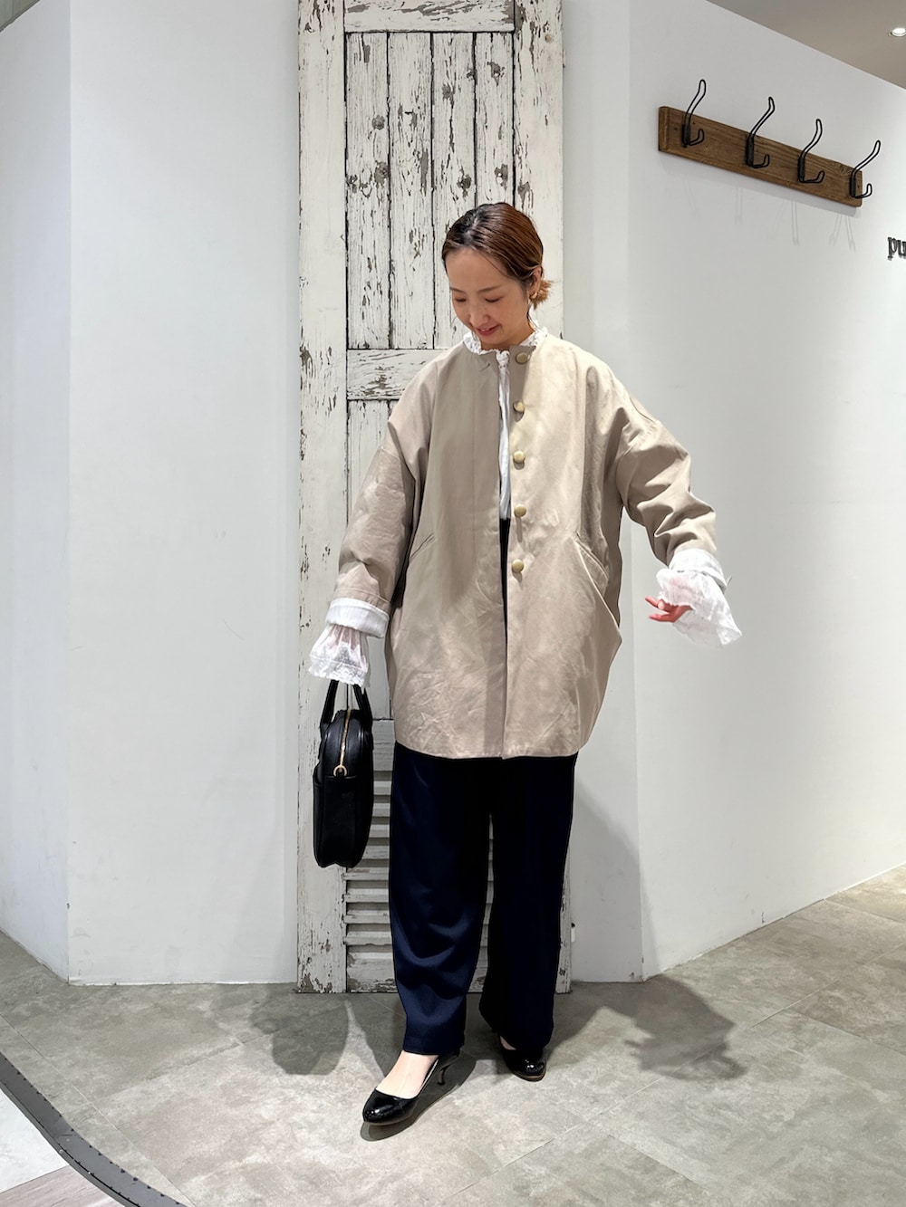 ホワイト系のシャツ/ブラウス、ブラック系のノーカラーコート、グレー系のスラックスを着用したレディースの冬コーディネートの2枚目の写真