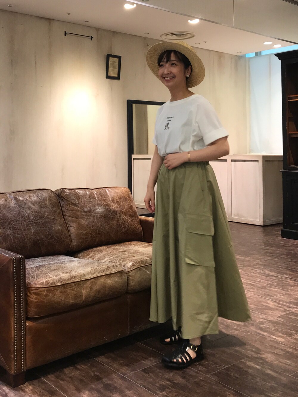 グリーン系のスカート、ブラック系のシューズ、ホワイト系のTシャツ/カットソーを着用したレディースの夏コーディネートの2枚目の写真