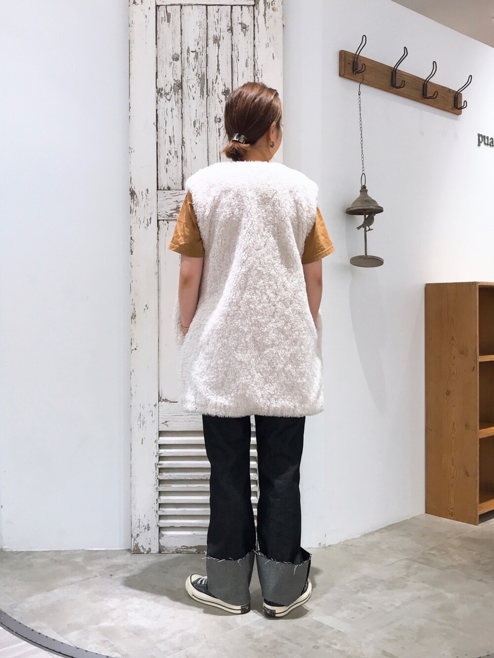 ホワイト系のベスト、ブラック系のデニムパンツ、ブラック系のスニーカーを着用したレディースの夏コーディネートの4枚目の写真