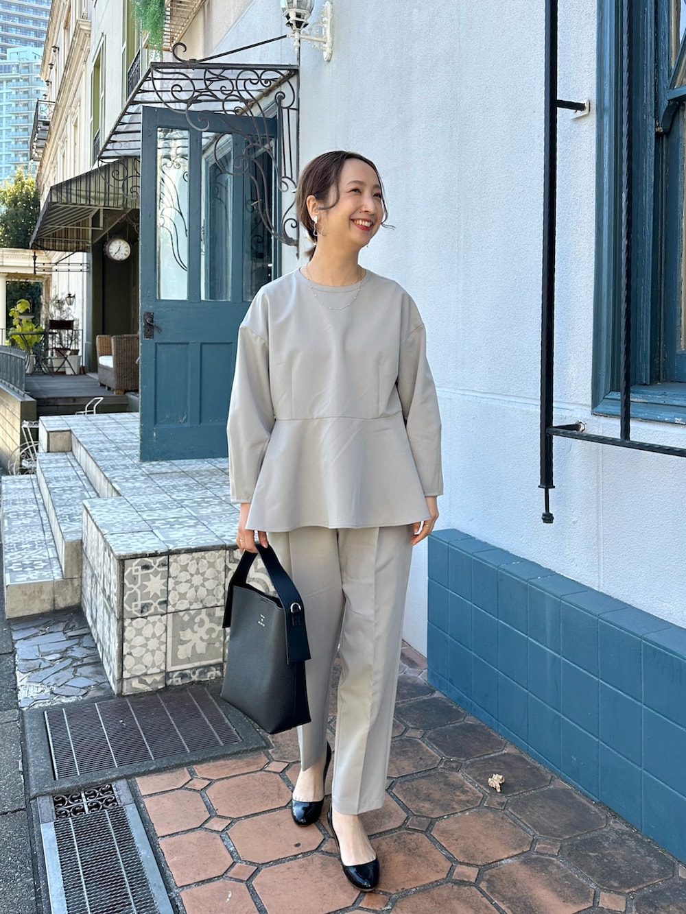 ホワイト系のノーカラージャケット、ベージュ系のスーツセット、ベージュ系のショルダーバッグを着用したレディースの冬コーディネートの2枚目の写真