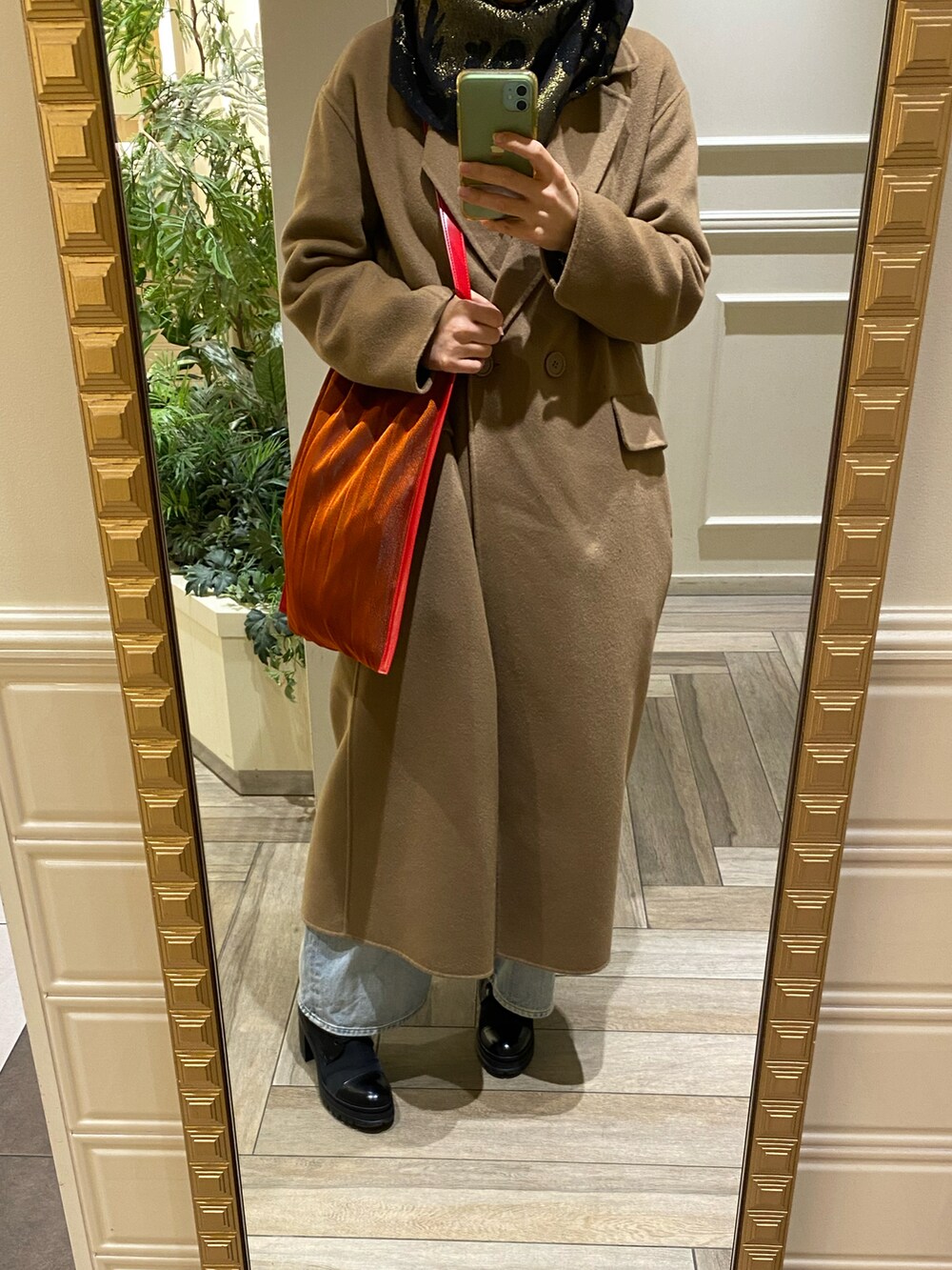 ブラック系のブーツ、オレンジ系のトートバッグ、ブラウン系のその他アウターを着用したレディースの春コーディネートの2枚目の写真