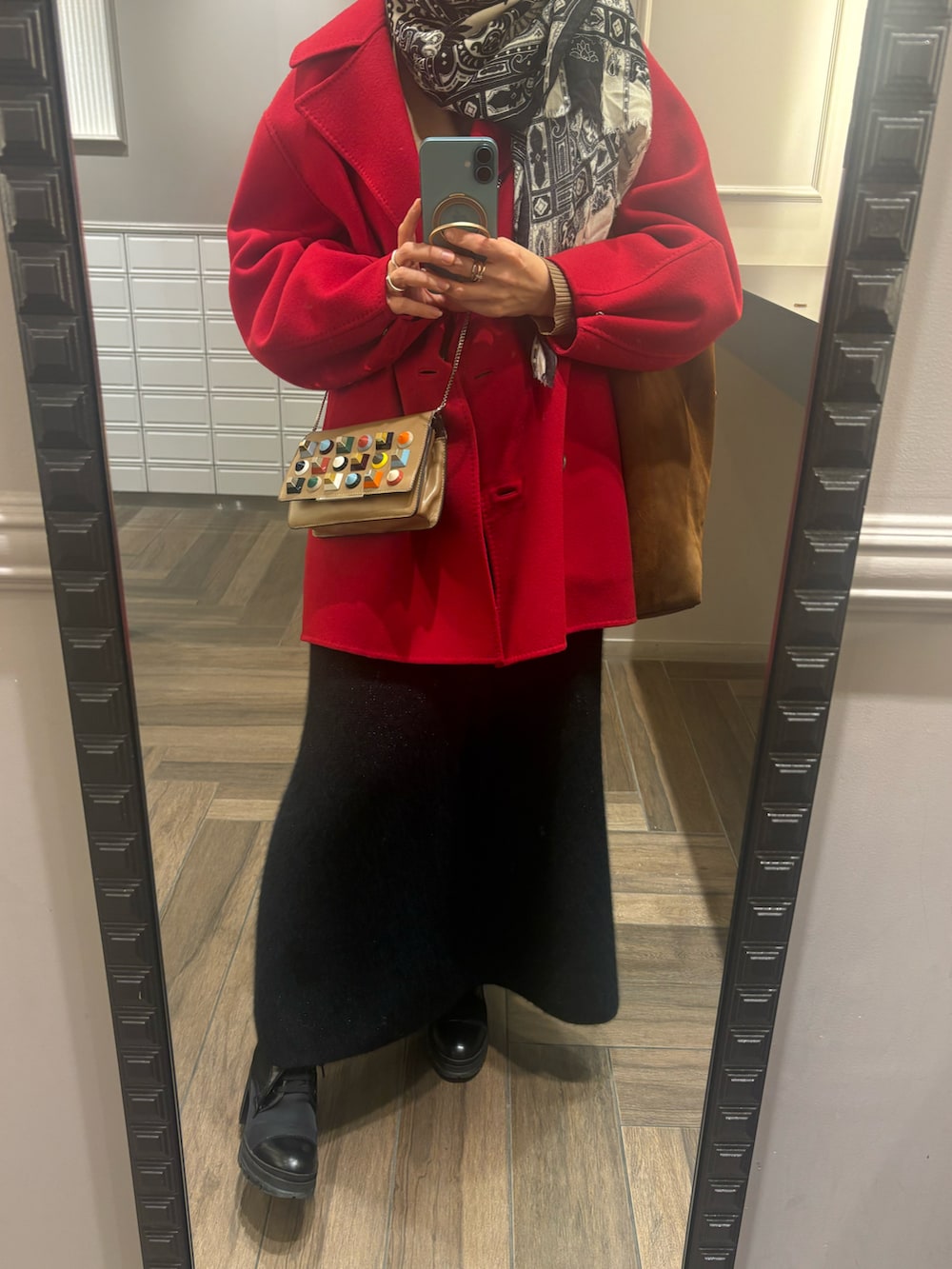 ブラック系のスカート、ベージュ系のニット/セーター、レッド系のピーコートを着用したレディースの春コーディネートの2枚目の写真
