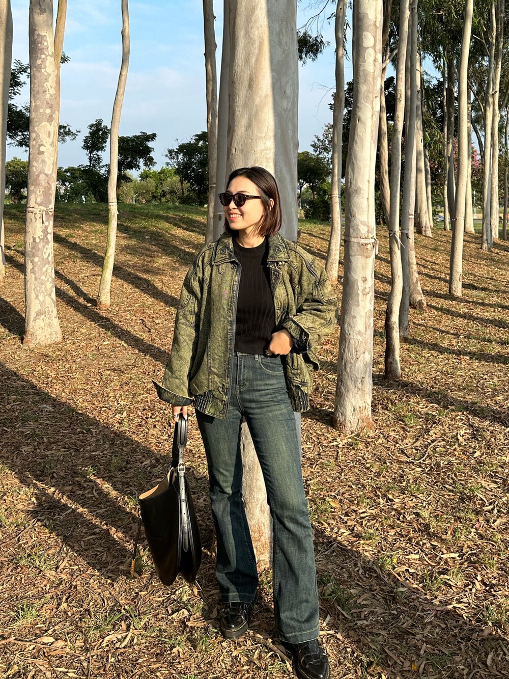 ブラック系のショルダーバッグ、ブラック系のサンダル、ブルー系のデニムパンツを着用したレディースの冬コーディネートの3枚目の写真