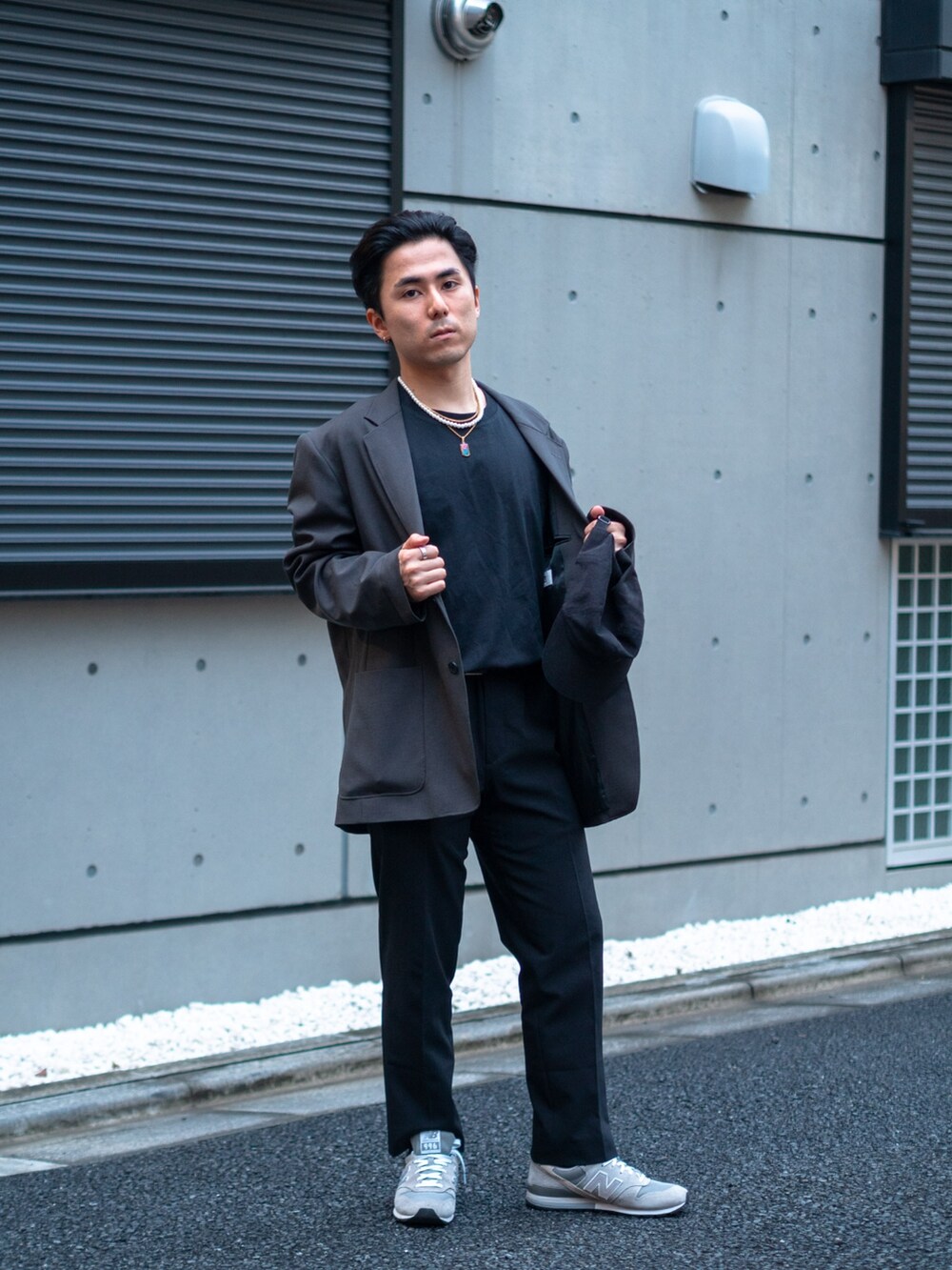 ブラック系のシャツ/ブラウス、グレー系のテーラードジャケット、ブラック系のスラックスを着用したメンズの春コーディネートの3枚目の写真