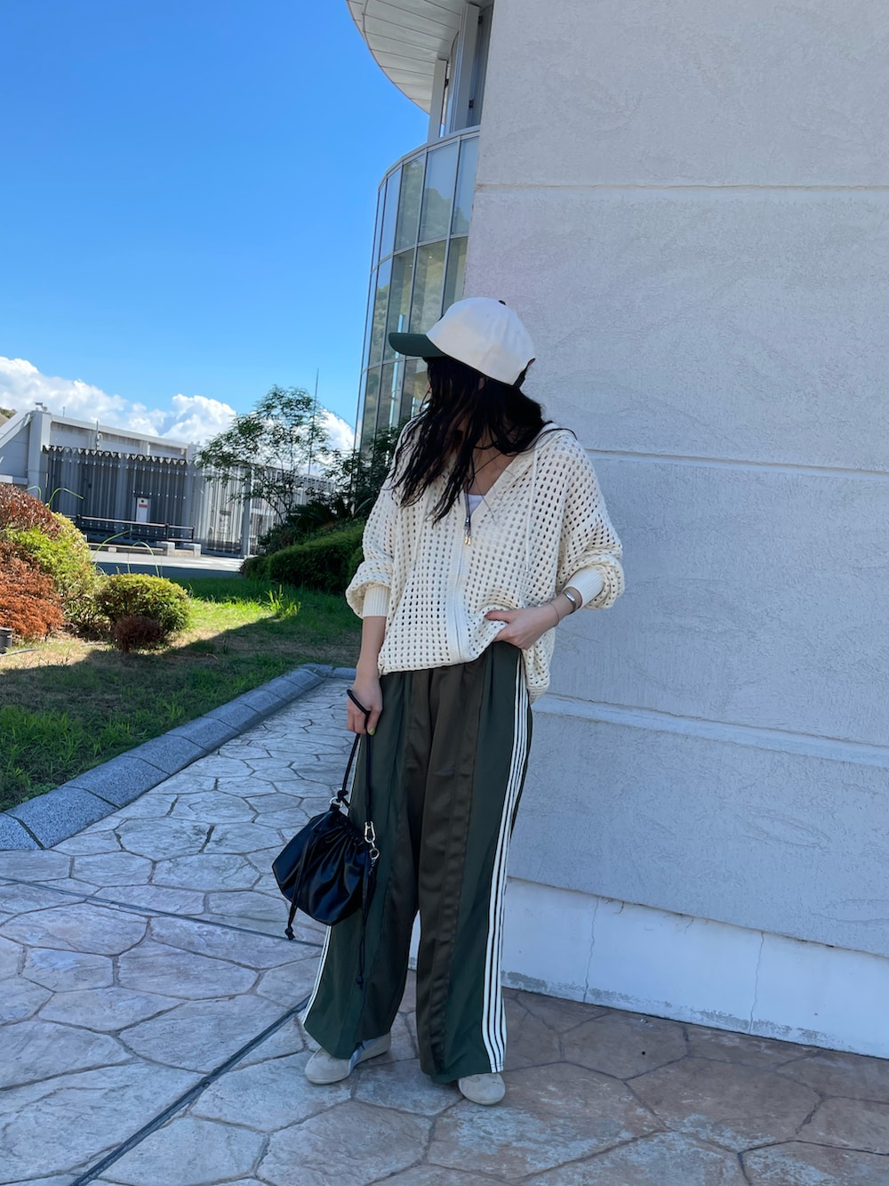 ホワイト系のパーカー、グリーン系のその他パンツ、ブラック系のショルダーバッグを着用したレディースの秋コーディネートの3枚目の写真