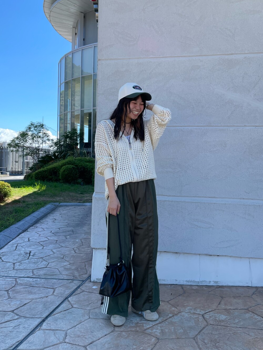 ホワイト系のパーカー、グリーン系のその他パンツ、ブラック系のショルダーバッグを着用したレディースの秋コーディネートの2枚目の写真