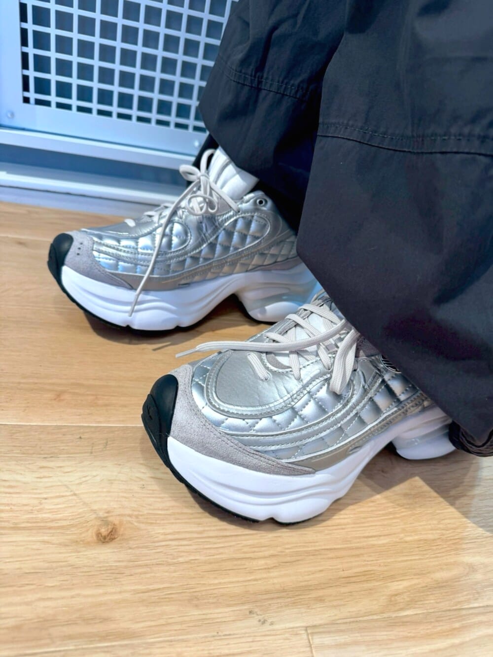 グレー系のその他パンツ、レッド系のTシャツ/カットソー、ホワイト系のスニーカーを着用したメンズの冬コーディネートの4枚目の写真