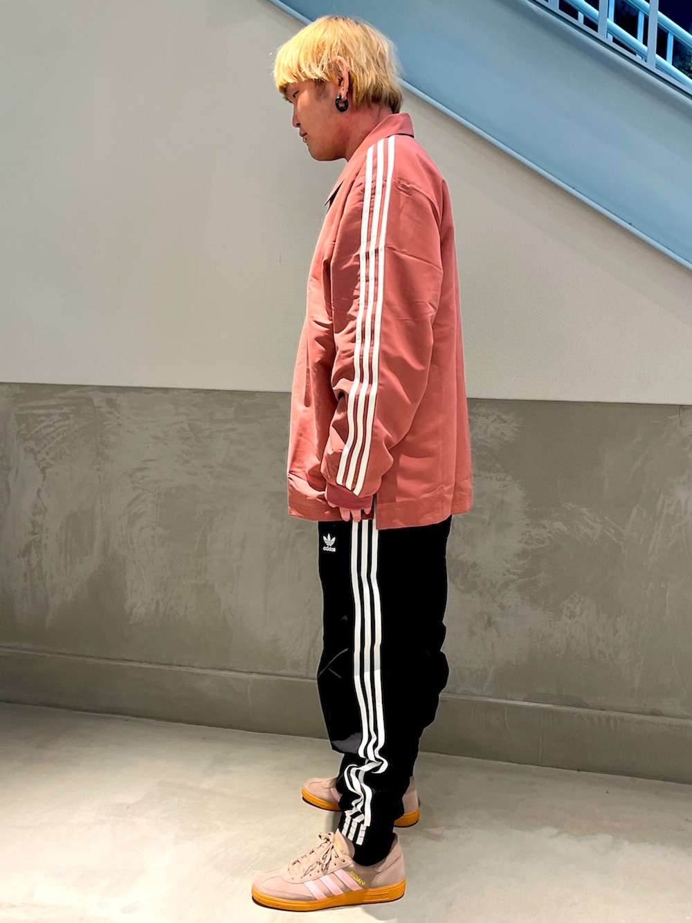 ピンク系のトップス、ブラック系のその他パンツ、ブラウン系のスニーカーを着用したメンズの冬コーディネートの2枚目の写真