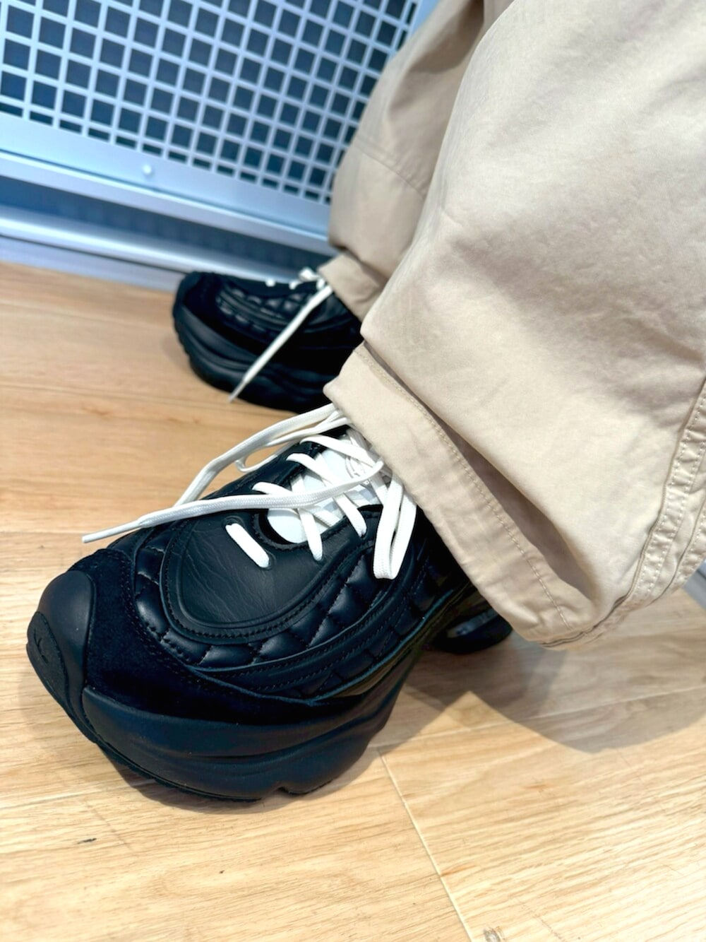 パープル系のパーカー、ベージュ系のその他パンツ、ブラック系のスニーカーを着用したメンズの冬コーディネートの4枚目の写真