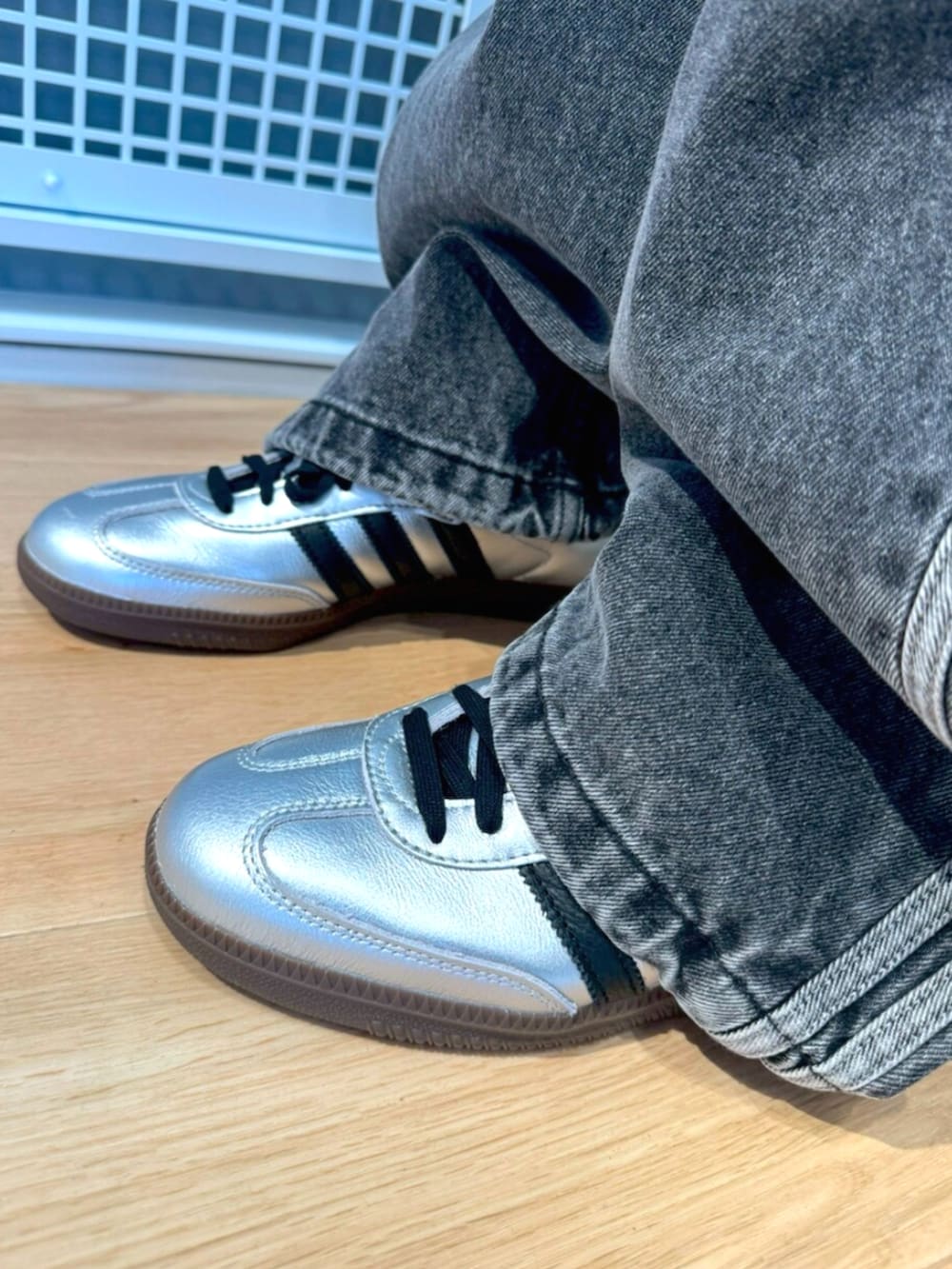 シルバー系のスニーカー、ブラック系のブルゾン、ブラック系のパンツを着用したメンズの冬コーディネートの4枚目の写真