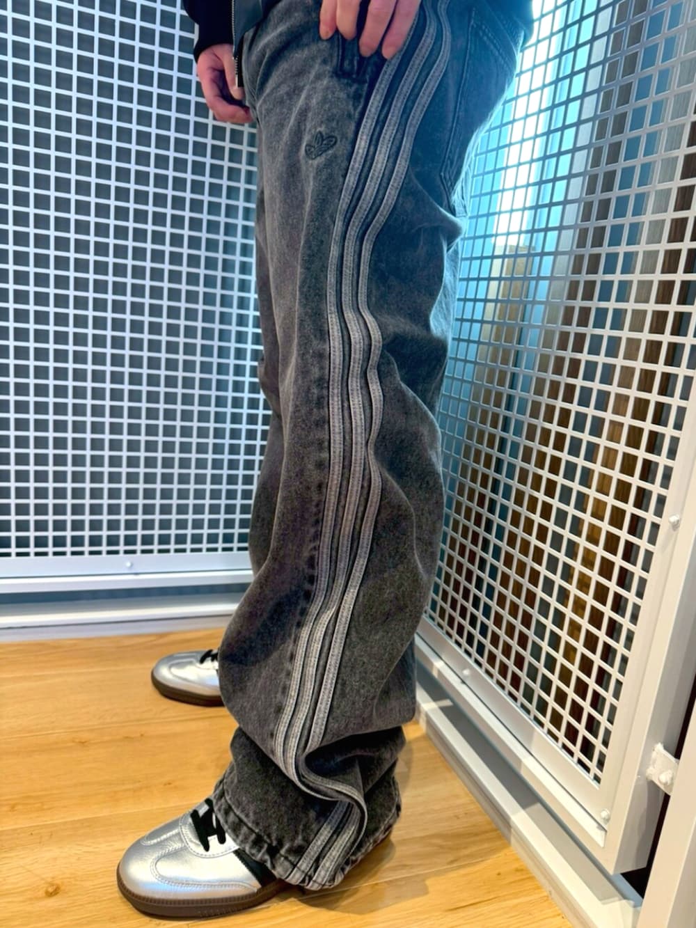 シルバー系のスニーカー、ブラック系のブルゾン、ブラック系のパンツを着用したメンズの冬コーディネートの3枚目の写真