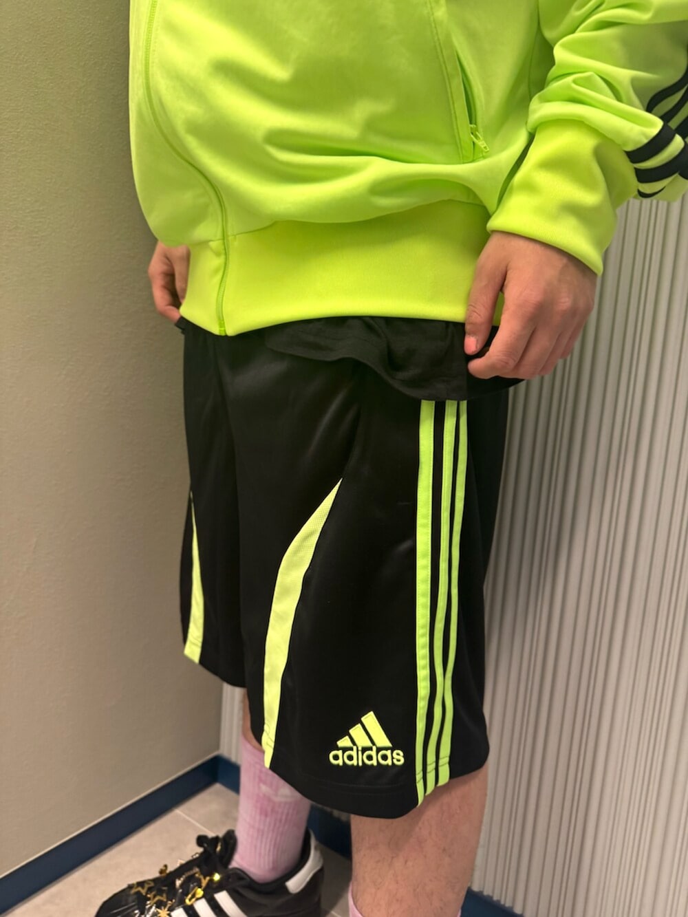 グリーン系のジャージ、ブラック系のその他パンツ、ブラック系のスニーカーを着用したメンズの秋コーディネートの3枚目の写真