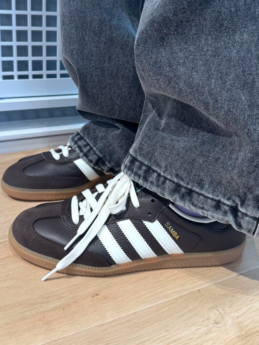 ブラウン系のシューズ、ブラウン系のジャージ、ブラック系のデニムパンツを着用したメンズの秋コーディネートの4枚目の写真