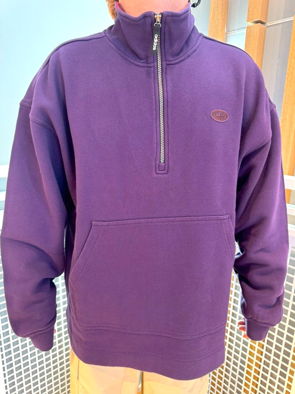 パープル系のパーカー、ベージュ系のその他パンツ、ブラック系のスニーカーを着用したメンズの冬コーディネートの2枚目の写真