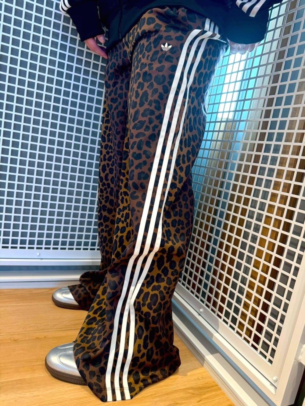 シルバー系のスニーカー、ブラック系のジャージ、ブラウン系のその他パンツを着用したメンズの冬コーディネートの3枚目の写真