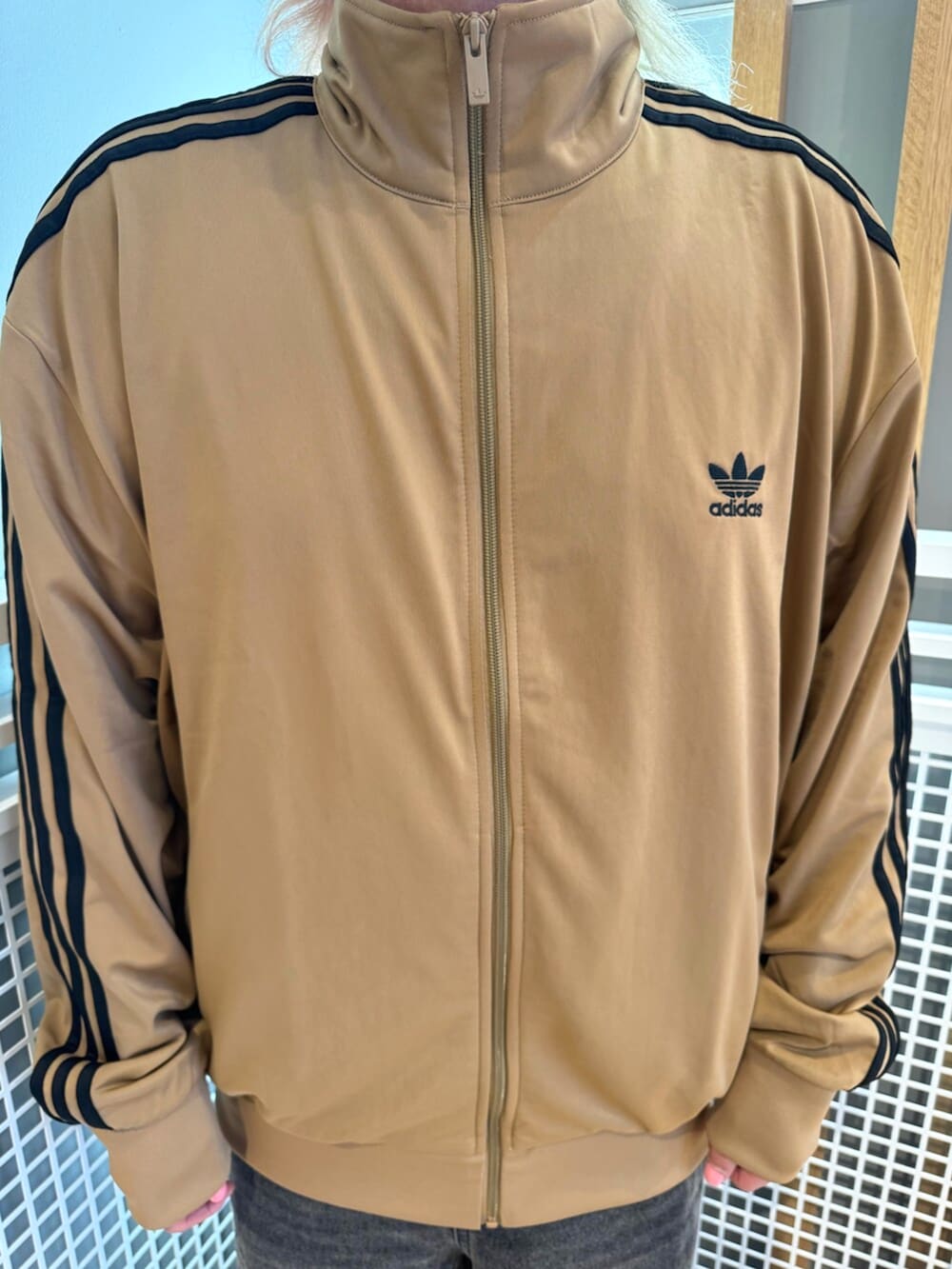 ブラウン系のシューズ、ブラウン系のジャージ、ブラック系のデニムパンツを着用したメンズの秋コーディネートの2枚目の写真