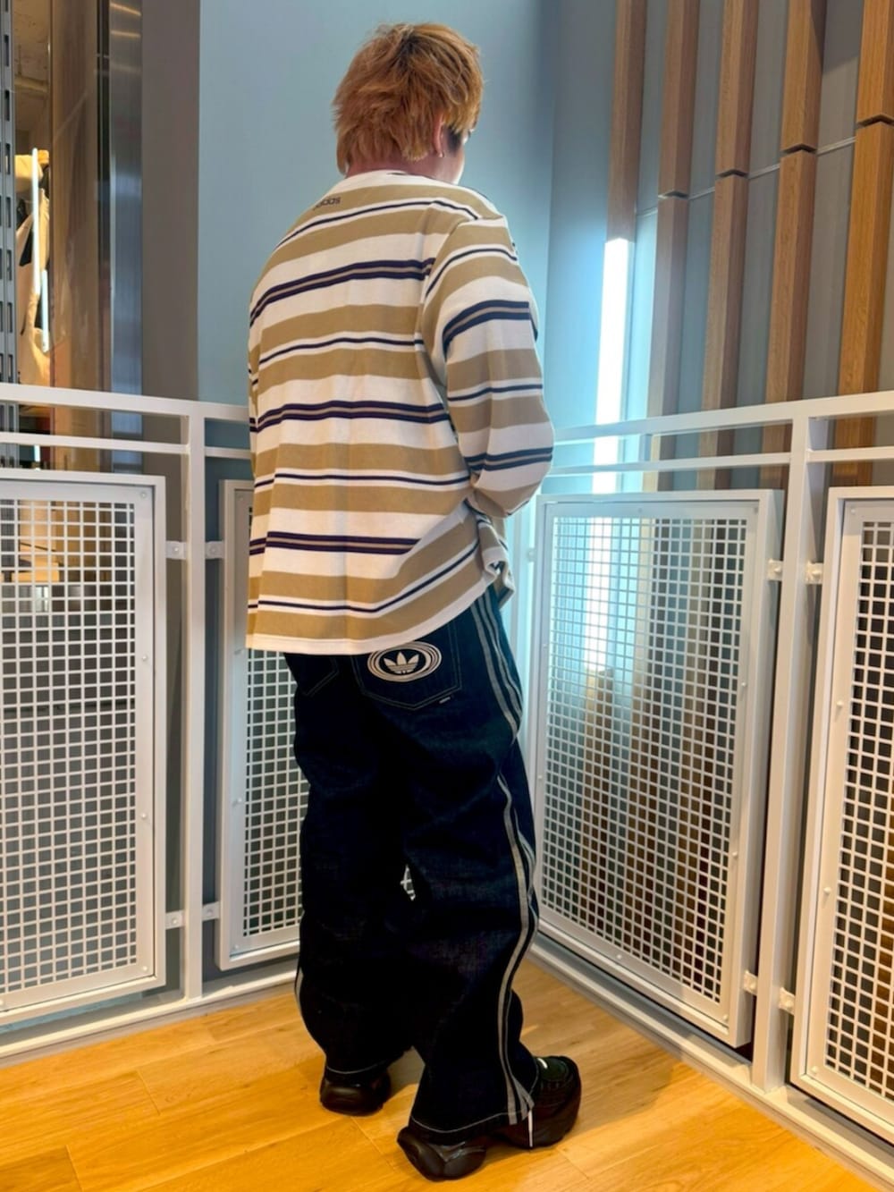 ホワイト系のTシャツ/カットソー、ブルー系のその他パンツ、ブラック系のスニーカーを着用したメンズの冬コーディネートの2枚目の写真